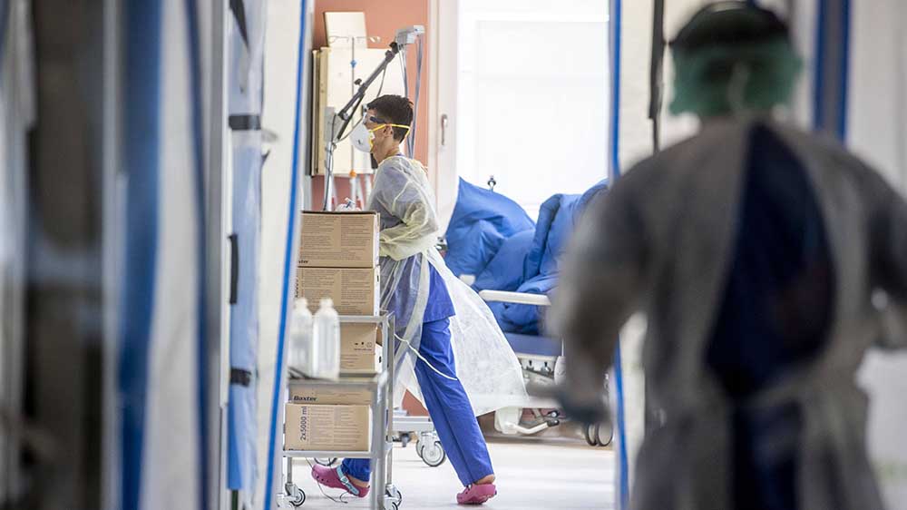 Flur einer Klinik, Arzt mit Maske
