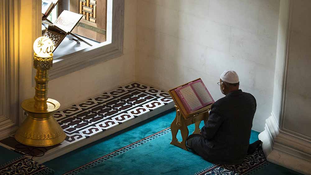 Am Fenster einer Moschee in Berlin-Neukölln betet ein Imam