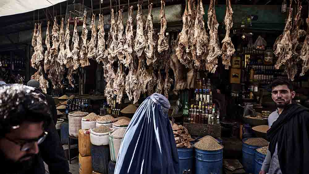 Mit Burka läuft diese Frau über einen Markt in Kabul