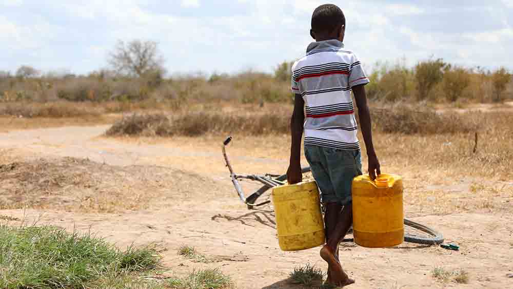 Ein Junge schleppt Wasser in einem kleinen kenianischen Dorf