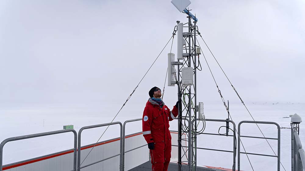 Karsten Böddeker bei der Antennenkontrolle auf dem Stationsdach der Forschungsstation