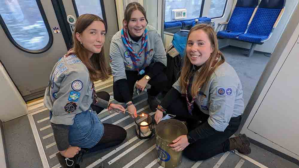 Pfadfinder hocken im Zug mit Licht in einer Lampe