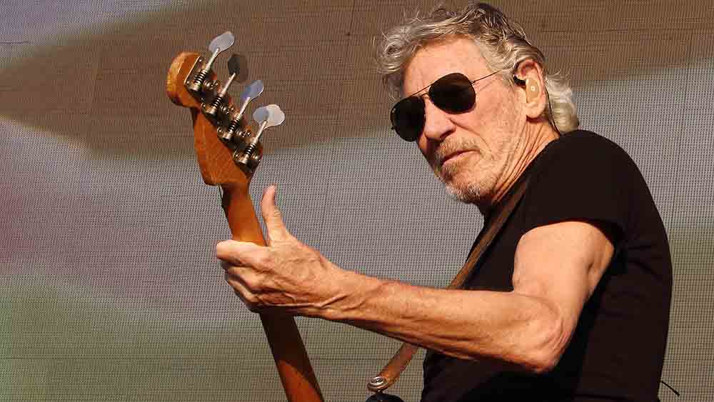 Waters mit Sonnenbrille und T-Shirt spielt auf Bühne Gitarre