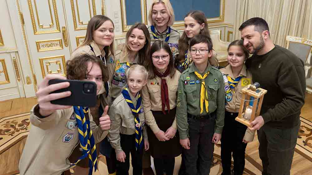Präsident Wolodymyr Selenskyj mit Pfadfindern, die das Friedenslicht nach Kiew gebracht haben