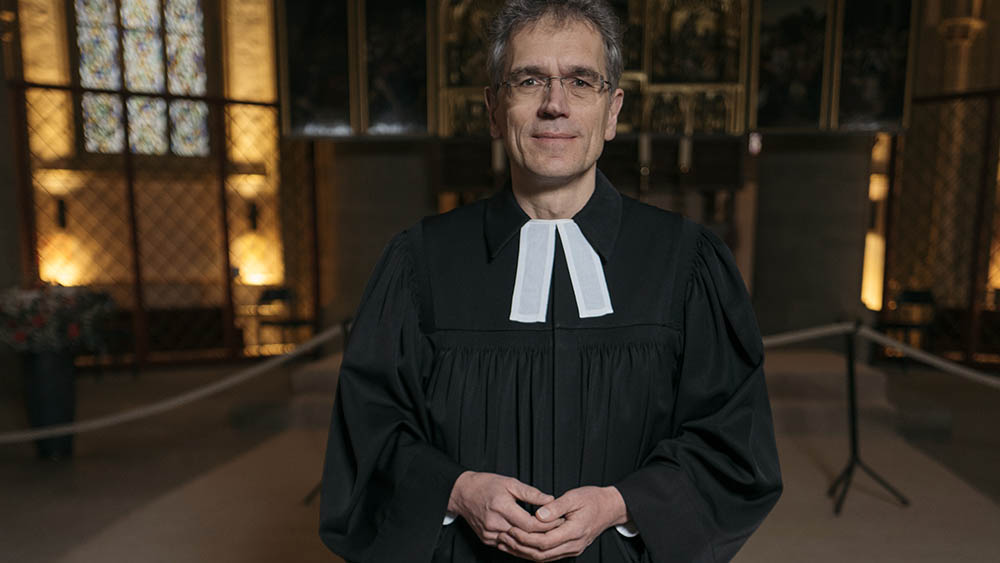 Mann im Talar vor Altar
