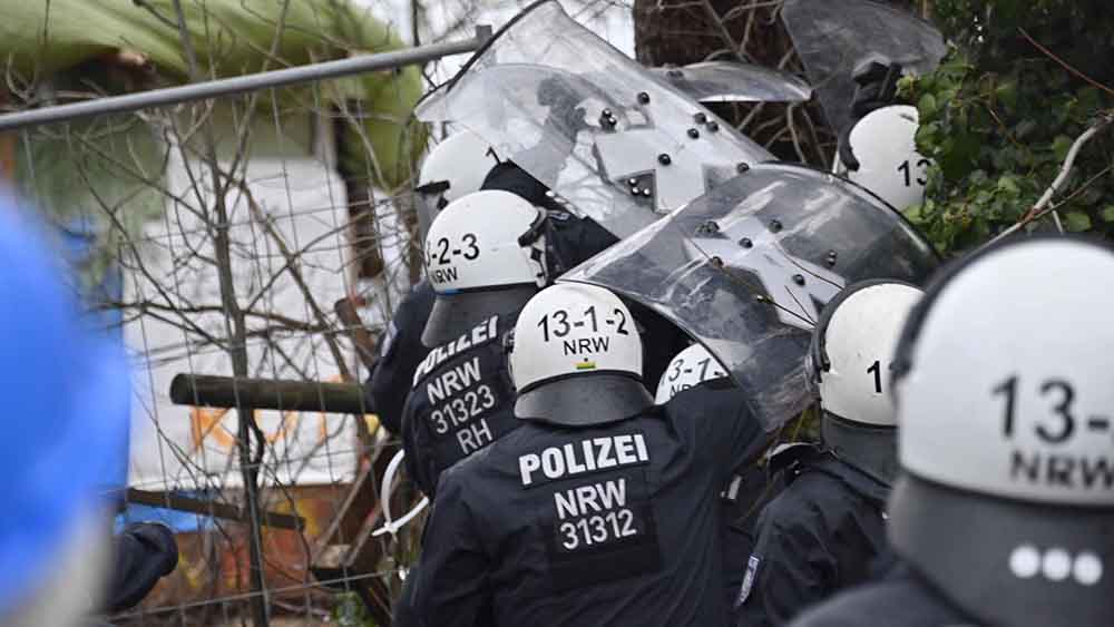 Mit Schildern schützen sich die Polizeikräfte gegen Wurfgeschosse