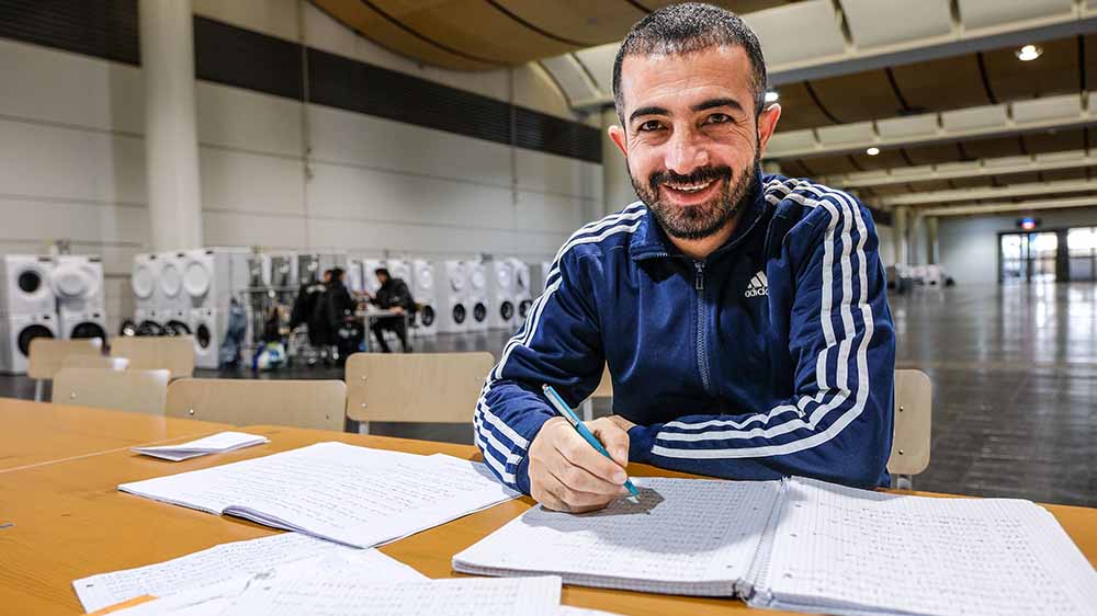 Kasim Sayan aus der Türkei lernt Deutsch, mitten in den Messehallen Hannover