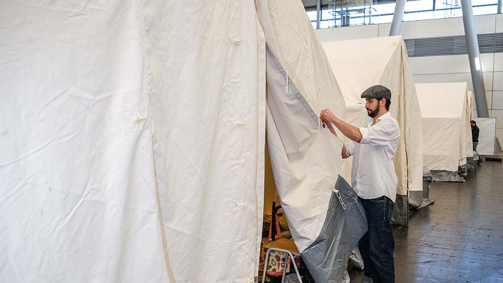 Dani Botrus zeigt sein aktuelles Zuhause: ein Zelt in den Messehallen Hannover