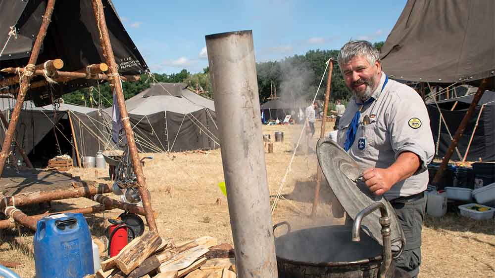 Martin Dressler  kocht in einem „Saubruehkessel“ Wasser auf (Großes Pfandfindertreffen)