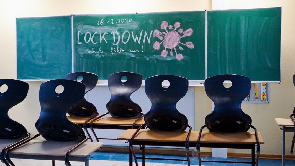 In einem leeren Schulzimmer steht "Lockdown" an der Tafel