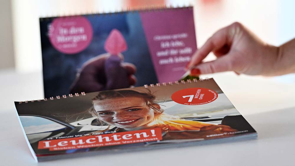 Zwei Tischkalender, Hände blättert den vorderen auf