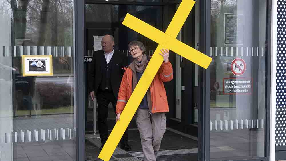 Cornelia Senne trägt das Kreuz heraus aus dem Aachener Polizeipräsidium