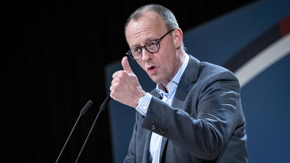 Merz im Sakko auf Bühne bei einer Rede
