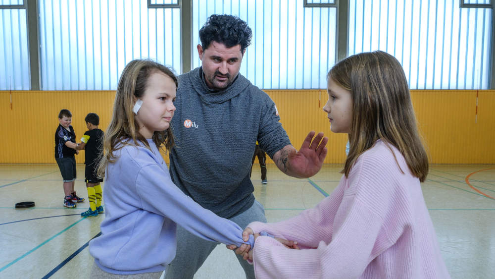 Milutin Susnica, Karateexperte und Trainer zeigt den zehnjährigen Mädchen Jule (rechts) und Josie wie sie sich verhalten können.