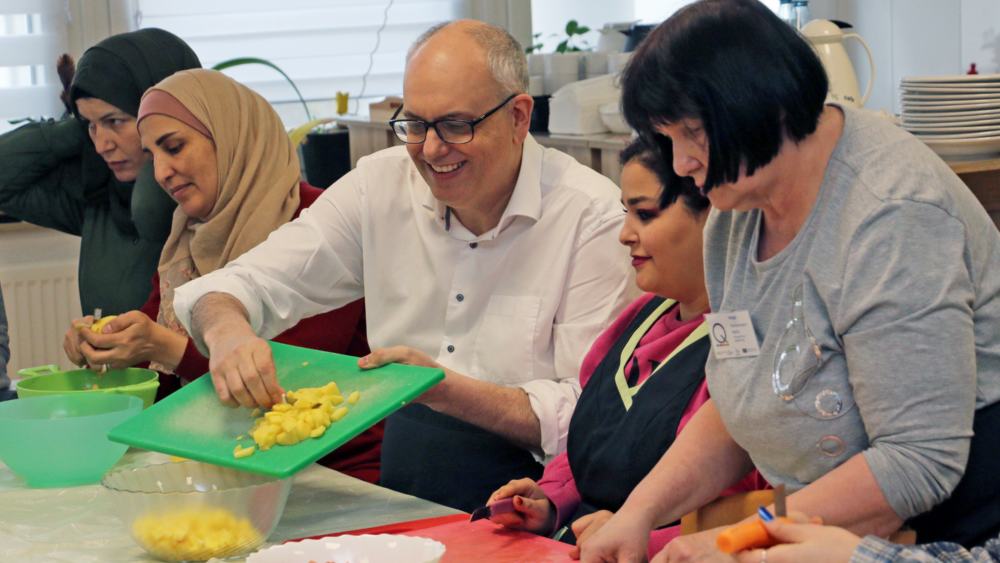 Bremens Bürgermeister Bovenschulte hilft beim Kochen einer warmen Mahlzeit in einem Bremer Mütterzentrum