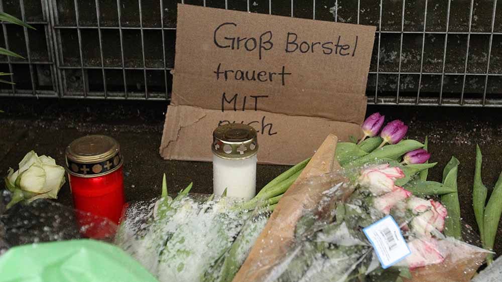 Blumen und Kerzen haben die Menschen am Tatort in Hamburg niedergelegt