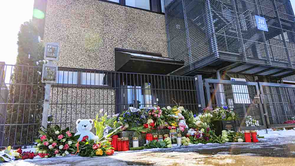 Vor dem Gebäude der Zeugen Jehovas haben Trauernde Kerzen und Blumen niedergelegt