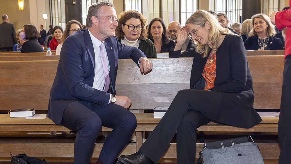 Mann und Frau sitzen auf Kirchenbank