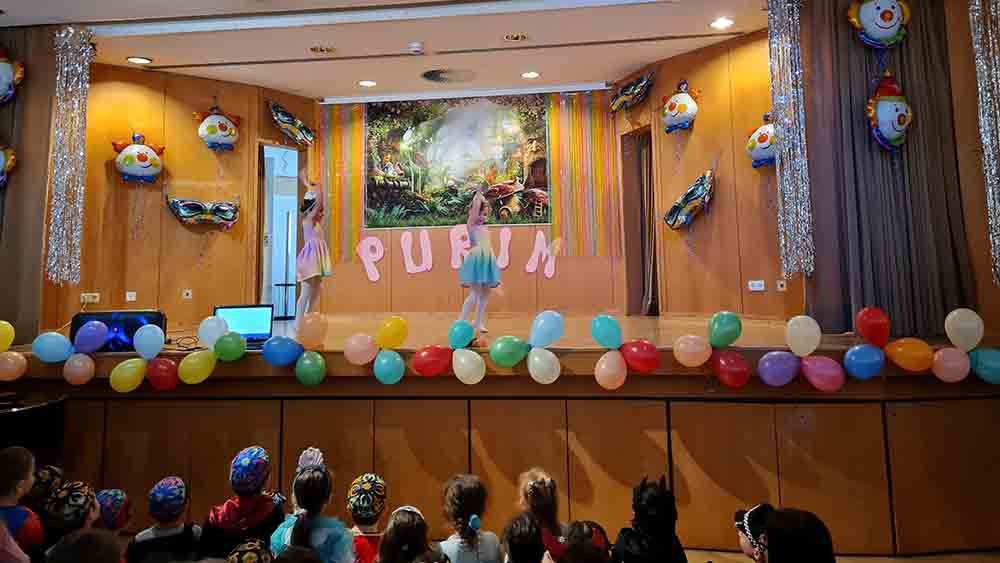 Kinder im Publikum. auf der Bühne tanzen zwei verkleidete Kinder