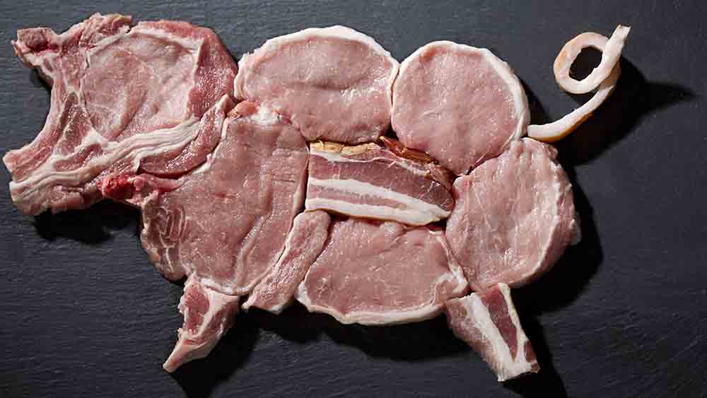 Rohe Fleisch-Stücke auf einem Brett, die den Körper eines Schweines nachstellen