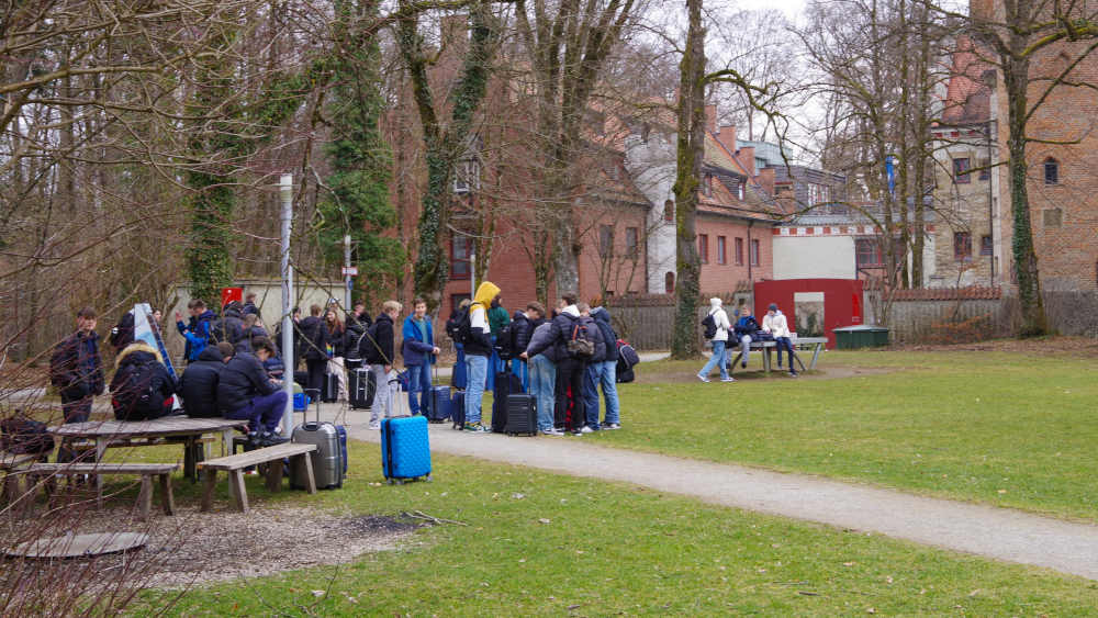 Schulklasse wartet vor einer Jugendherberge