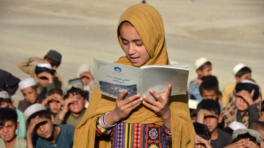 Ein afghanisches Mädchen liest aus einem Buch vor während einer Unterrichtsstunde einer mobilen Schule in der Provinz Kandahar