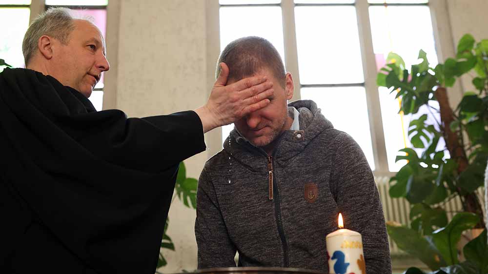 Bischof Christian Stäblein tauft am Ostersonntag diesen Mann in der Berliner Genezarethkirche