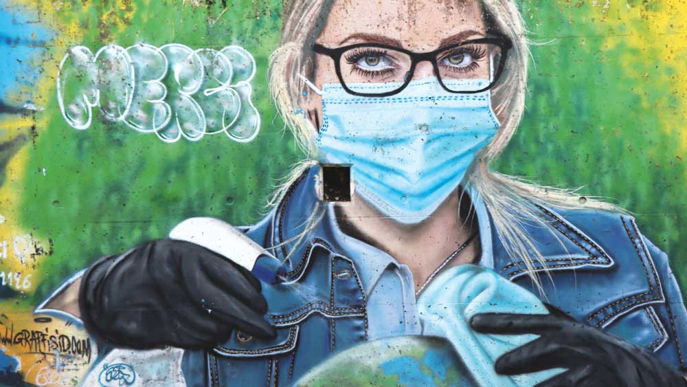 Graffito: Frau mit Schutzmaske putzt den Planeten Erde