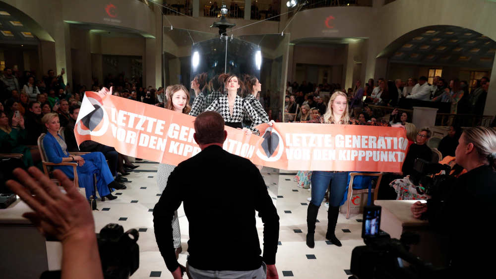 Aktivistinnen der Letzten Generation stören die Anja Gockel Fashion Show am 18.01.2023 im Rahmen der Berlin Fashion Week im Hotel Adlon Kempinski Berlin
