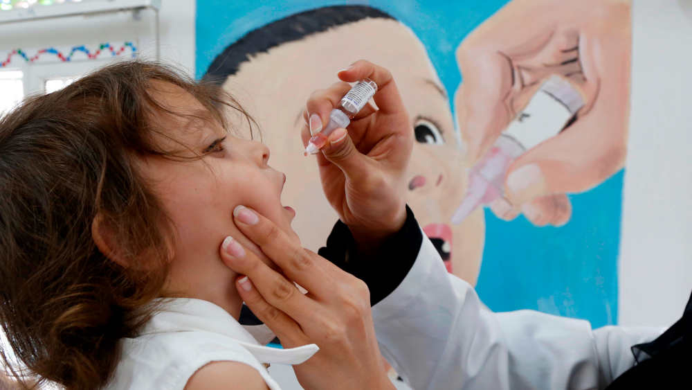 in medizinischer Mitarbeiter verabreicht einem Kind am 28. November 2020 in Sanaa, Jemen, eine Dosis Polio-Impfstoff
