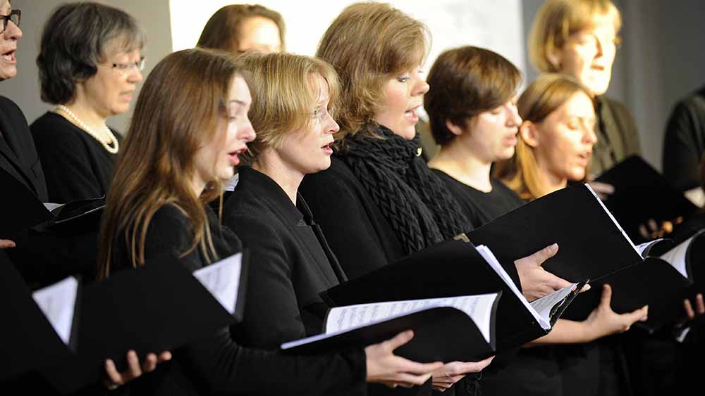 Fünf Frauen in schwarzer Kleidung singen als Teil eines Chores