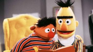 Die Figuren Ernie und Bert schauen in ein Buch