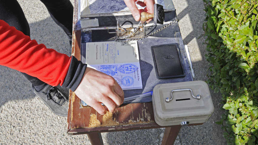 Pilger stempelt seinen Pilgerausweis in der Nähe vom spanischen Pamplona