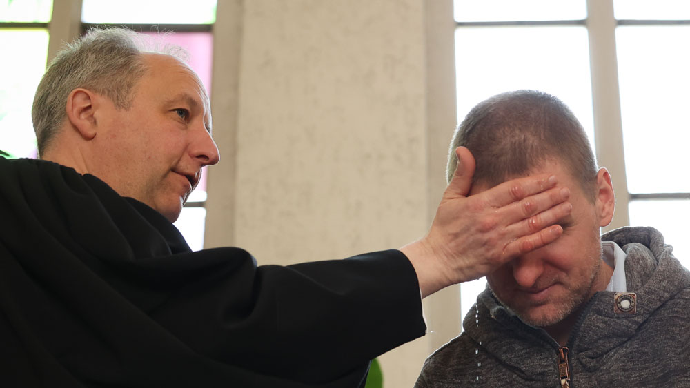 Der Bischof der Evangelischen Kirche Berlin-Brandenburg-schlesische Oberlausitz, Christian Stäblein, tauft einen Mann beim Pop-up-Tauffest am Ostersonntag in der Neuköllner Genezarethkirche in Berlin