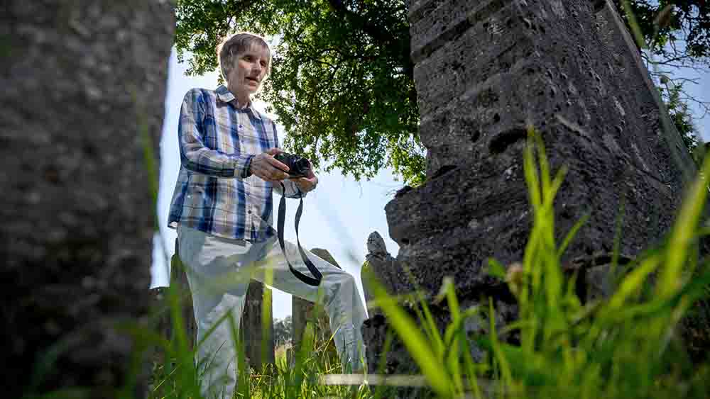 Die Theologin Monika Berwanger fotografiert Grabsteine auf dem Friedhof in Allersheim bei Würzburg