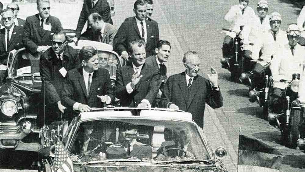 Im Cabrio durch Berlin (v.l): US-Präsident John F. Kennedy, Berlins Regierender Bürgermeister Willy Brandt und Bundeskanzler Konrad Adenauer