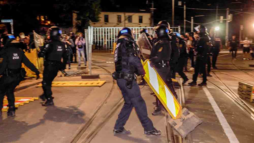 Polizisten in Kampfmontur räumen Sperren weg