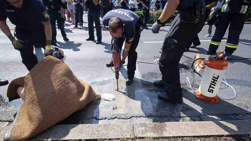Mit schwerem Gerät musste die Polizei die Aktivisten von der Straße lösen