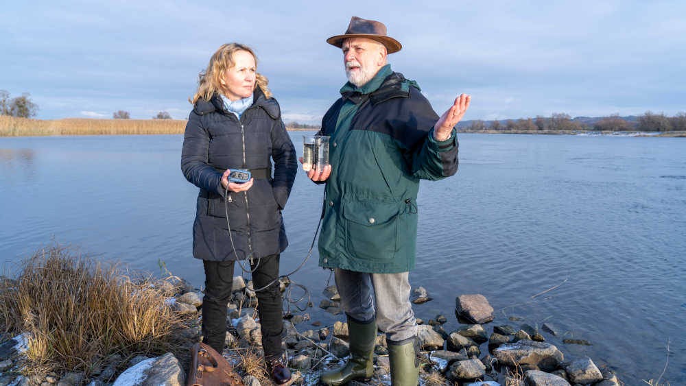 Ministerin Lemke und Dr. Micheal Tautenhahn, stellvertretender Nationalparkleiter, haben gemeinsam eine Wasserprobe an der Oder entnommen