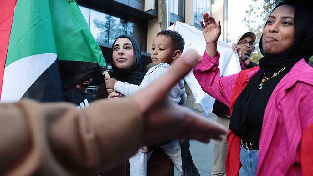 Menschen auf der Straße mit der Fahne des Sudan