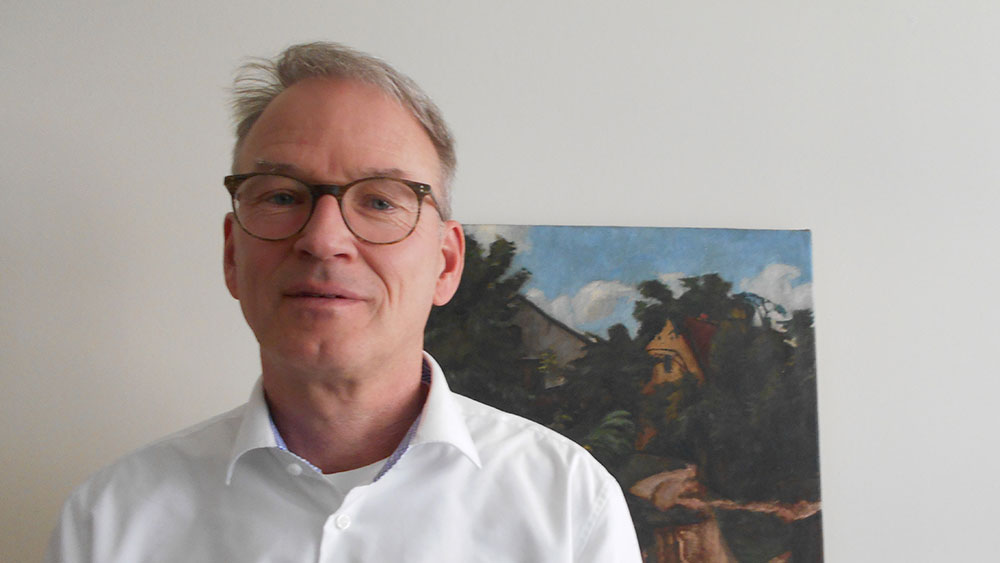Stephan Groscurth in seinem Büro im Berliner Verwaltungsgericht. Im Hintergrund hängt ein Bild der Stadt Lebus, gemalt von Wilhelm Schmidt-Petit. Groscurth hat es bei der EKBO-Kunstauktion erstanden