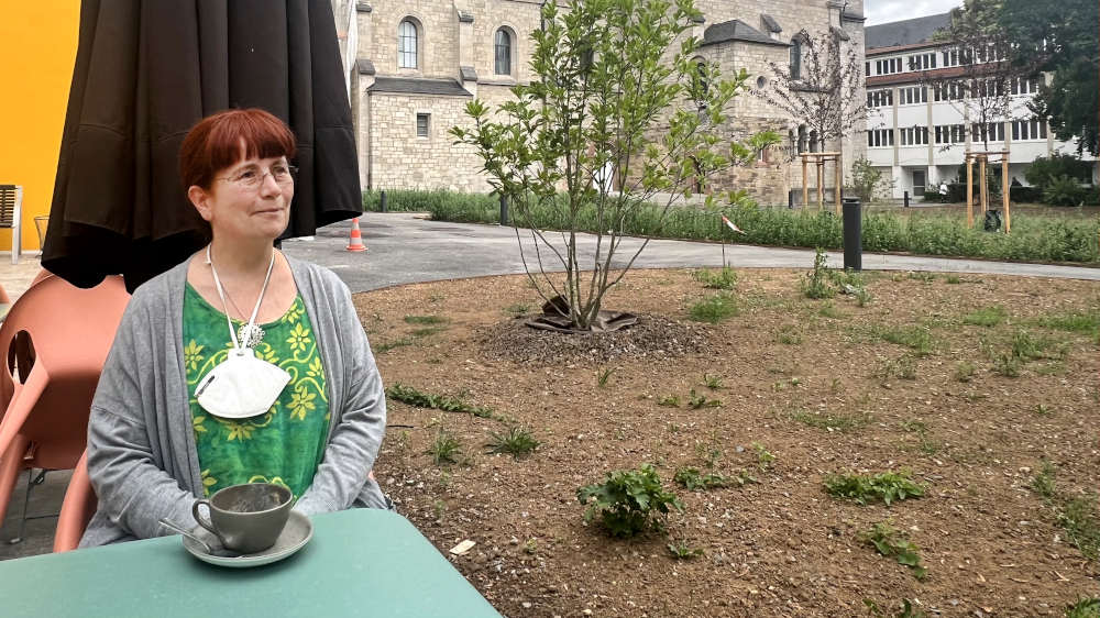 Karen Braun sitzt im Aussenbereich eines Cafes in Würzburg