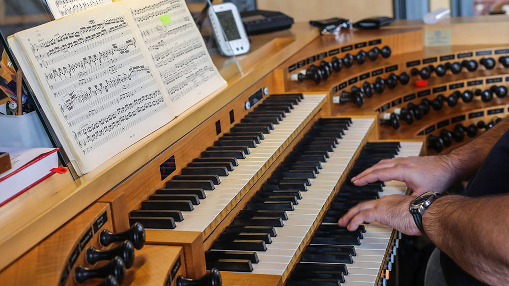 Mann spielt an der Orgel
