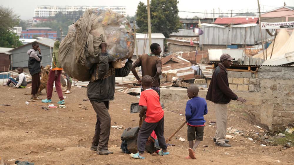 Müllsammler auf dem Weg zum Verkauf von gesammeltem Plastikmüll in Kibera in Nairobi