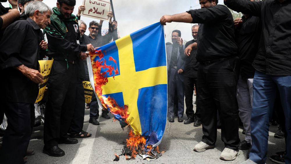 Protestierende gegen die Koran-Verbrennungen in Irans Hauptstadt Tehran verbrennen die schwedische Flagge