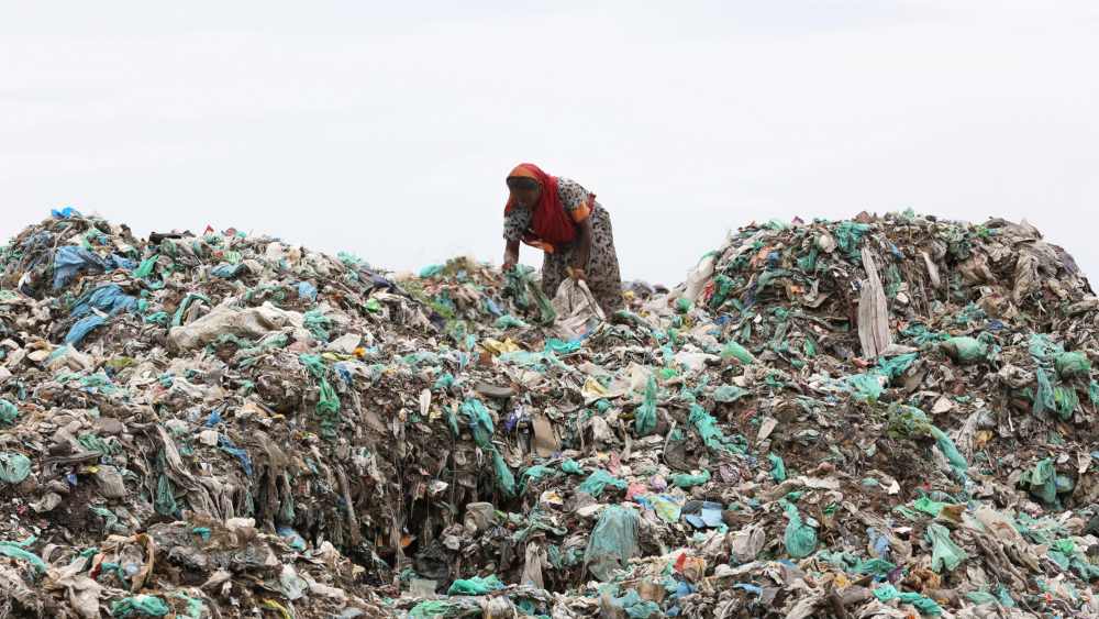 Eine Sammlerin auf einem Plastik-Müllberg in Bangladesh