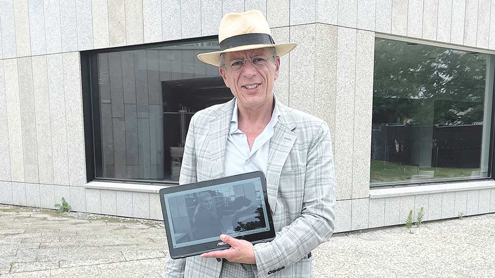 Stadtführer Torsten Flüh vor der Staatsbibliothek zu Berlin in der Potsdamer Straße. Mit Szenenfotos macht er die Drehorte des Films „Der Himmel über Berlin“ anschaulich