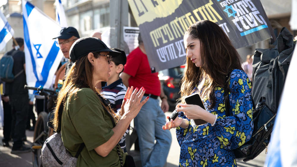 Eine israelische Reservistin spricht mit einer orthodoxen Frau während einer Protestaktion in Bnei Brak
