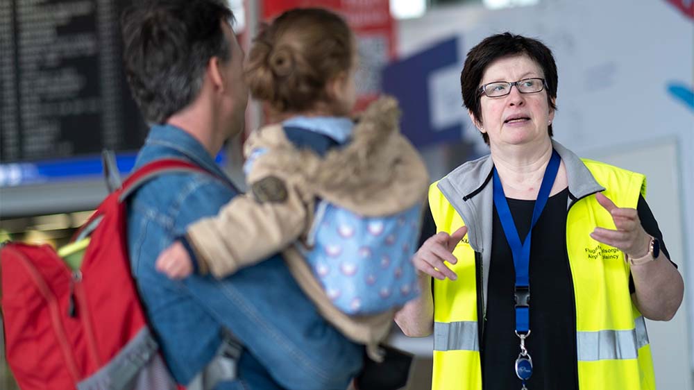 Die evangelische Pfarrerin Bettina Klünemann der kirchlichen Flughafenseelsorge spricht mit Reisenden am Flughafen Frankfurt im Terminal 1