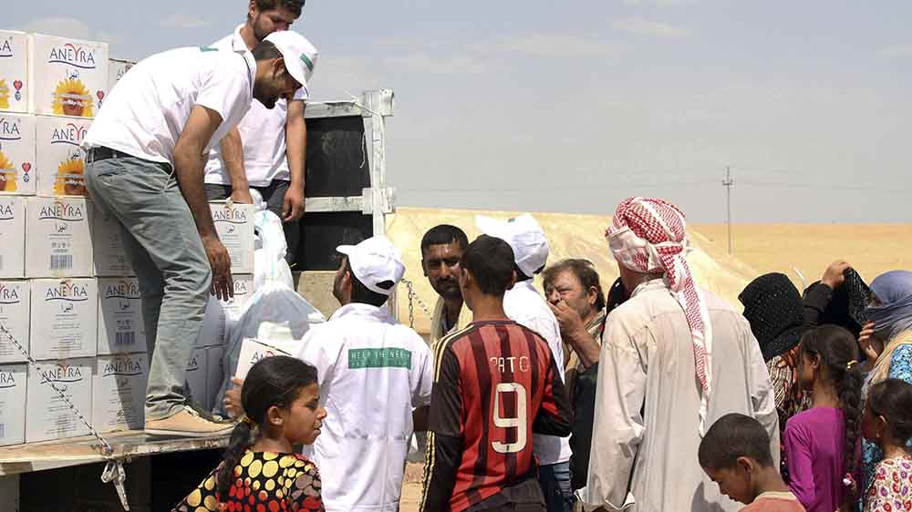 Helfer verteilen Lebensmittel im nordirakischen Erbil (Archiv)